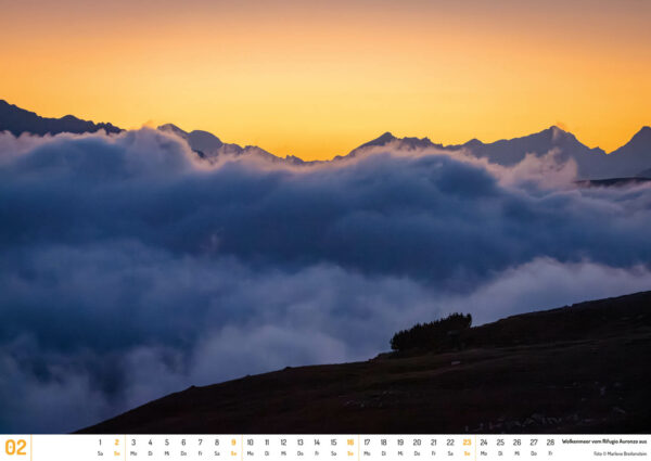 2025 Dolomiten Calendar, February. Photograph of a beautiful golden sunset glow, above a blue cloud ocean, in the mountains.