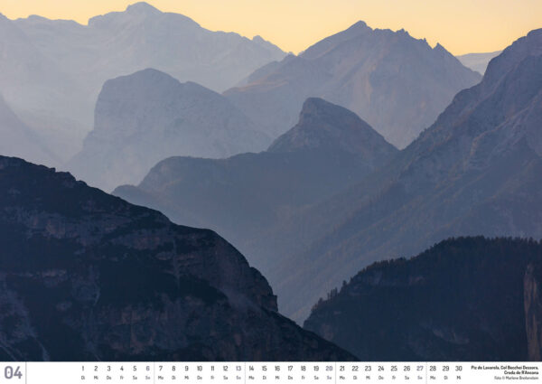 2025 Dolomiten Calendar, April. Photograph of layers of blue mountains against a yellow sky.