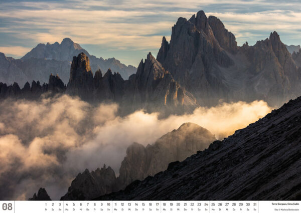 2025 Dolomiten Calendar, August. Photograph of rugged mountain spires, shrouded in low clouds.