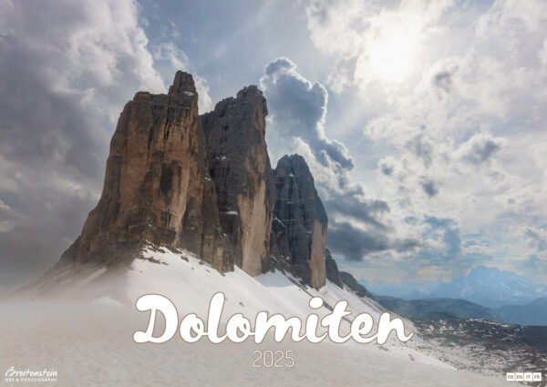 2025 Dolomiten Calendar, front cover. Photograph of Drei Zinnen (the Three Peaks of Lavaredo) in snow, under a dramatic sky.